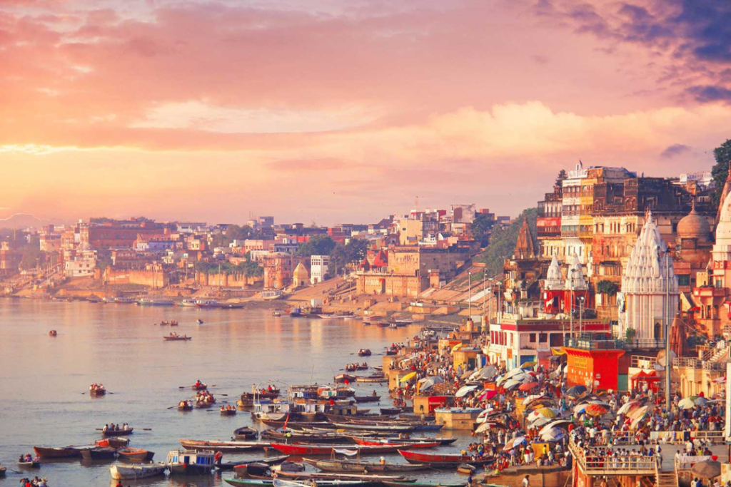 Sacred Ghats and boats on the Ganges River during sunrise in Varanasi – a spiritual and cultural highlight of India.